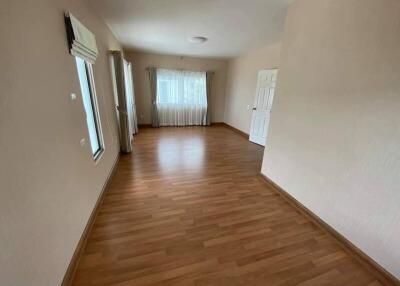 Spacious empty living room with wooden flooring and large windows