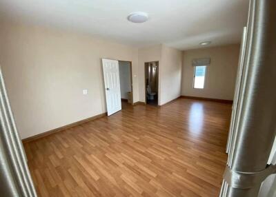 Spacious living room with wooden flooring and natural light