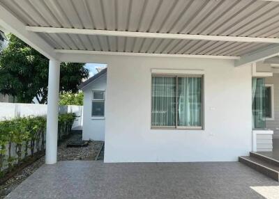 covered outdoor area of a property with tiled flooring, white walls, and large windows