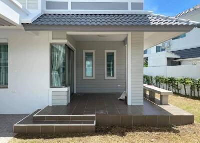 Outdoor patio area with tile flooring and garden view