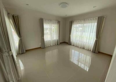 Spacious living room with large windows and tiled floor