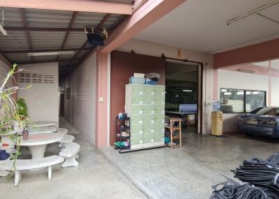 Spacious garage and seating area with storage cabinets, parked car, and outdoor furniture