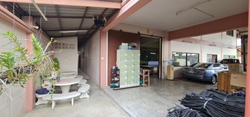 Spacious garage and seating area with storage cabinets, parked car, and outdoor furniture