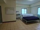 Spacious bedroom with tiled floor and double bed