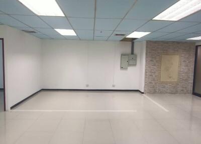 Spacious vacant room with tiled floor and panel ceiling