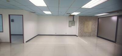 Spacious vacant room with tiled floor and panel ceiling