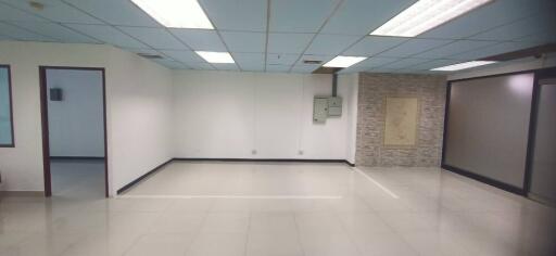 Spacious vacant room with tiled floor and panel ceiling