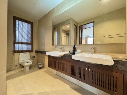 Spacious bathroom with dual sinks and a toilet