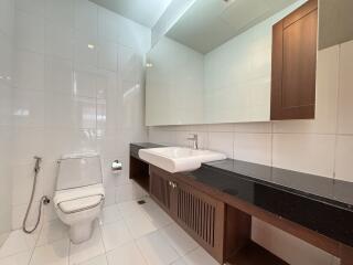 Modern bathroom with large mirror and wooden accents