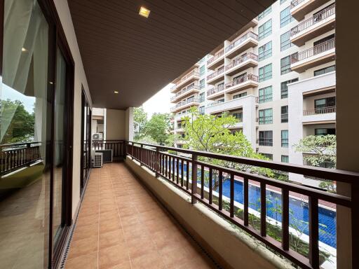 Spacious balcony with pool and building view