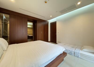 Modern bedroom with wooden accents and additional sleeping space