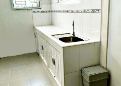 Simple kitchen with white cabinetry and tiled floor