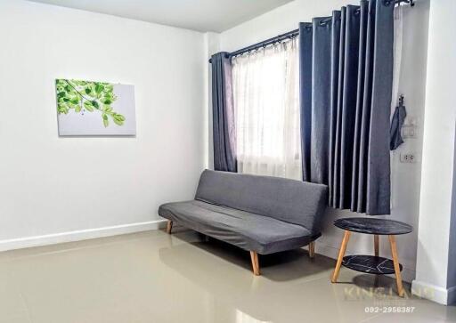 Minimalist living room with gray sofa, side table, and framed artwork