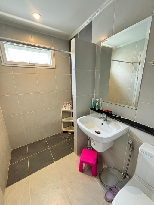 Modern bathroom with stand-alone sink, large mirror, shower area, and window