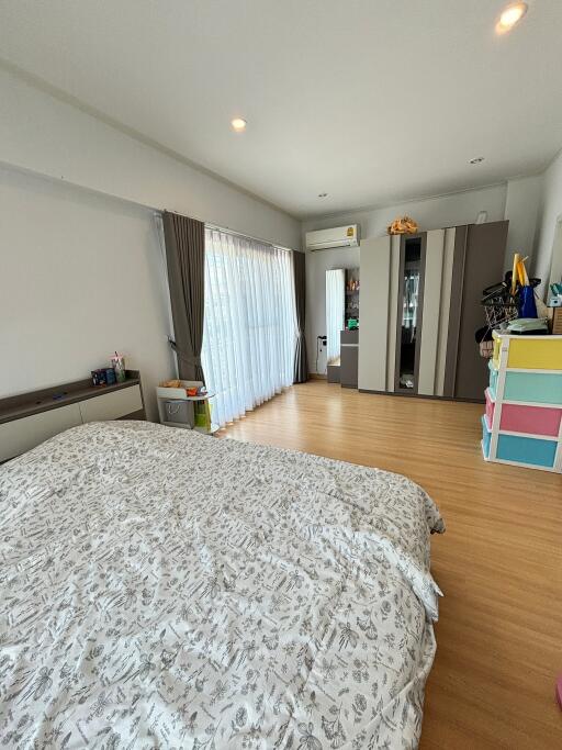 Modern bedroom with wooden flooring and contemporary furnishings