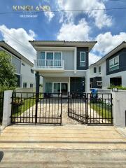 Front view of a contemporary two-story house with gated entrance