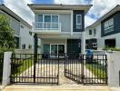 Front view of a contemporary two-story house with gated entrance