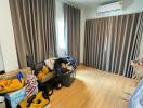 bedroom with wooden flooring and gray curtains