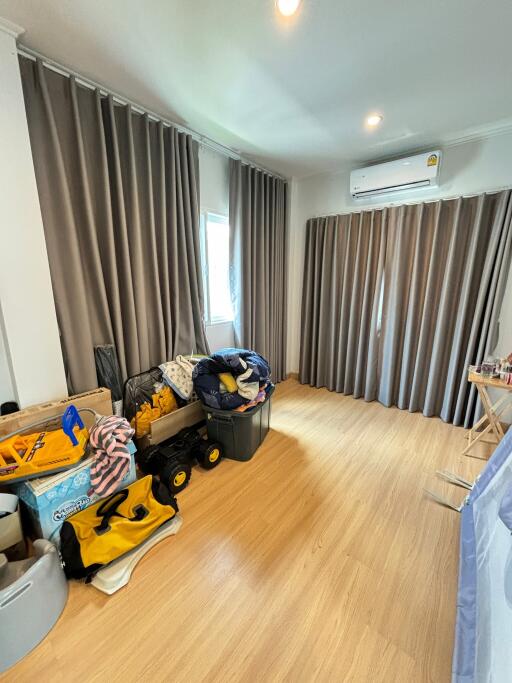 bedroom with wooden flooring and gray curtains