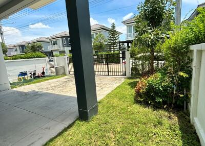 View of the front yard with driveway and gate