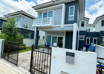 Two-story modern house with a small yard and gated driveway