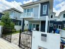 Two-story modern house with a small yard and gated driveway