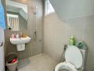 photo of a bathroom with a sink, toilet, and shower area