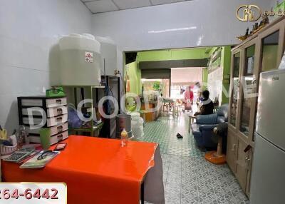 Living area with red table, storage cabinets, water container, and visible adjacent dining area