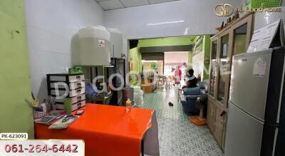 Living area with red table, storage cabinets, water container, and visible adjacent dining area