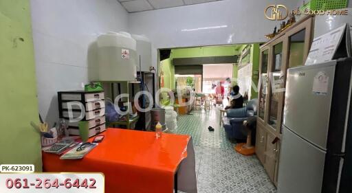 Living area with red table, storage cabinets, water container, and visible adjacent dining area