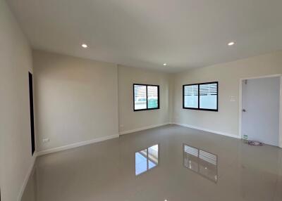 Spacious empty living room with large windows and tiled floor