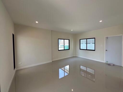 Spacious empty living room with large windows and tiled floor