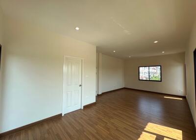 Spacious living room with wooden flooring and ample natural light