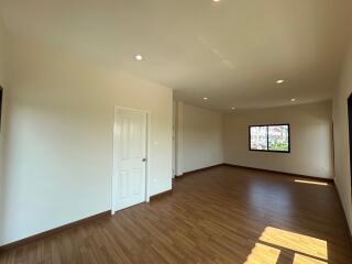 Spacious living room with wooden flooring and ample natural light