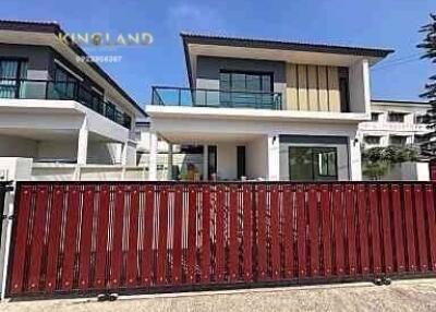 Modern two-story house with a red fence and balcony