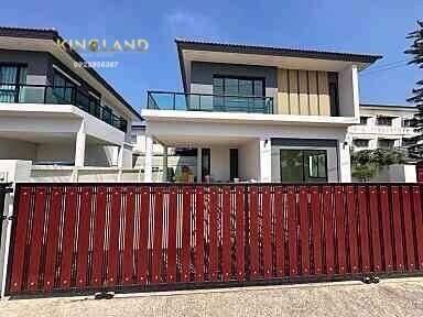 Modern two-story house with a red fence and balcony