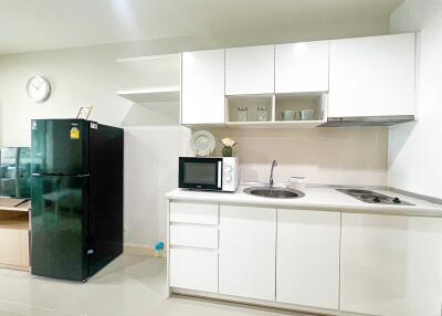 Modern kitchen with white cabinetry, countertop appliances, and a refrigerator