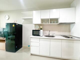 Modern kitchen with white cabinetry, countertop appliances, and a refrigerator