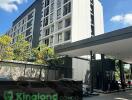 Exterior view of a condominium building on a sunny day with signage 'Kingland Condo'