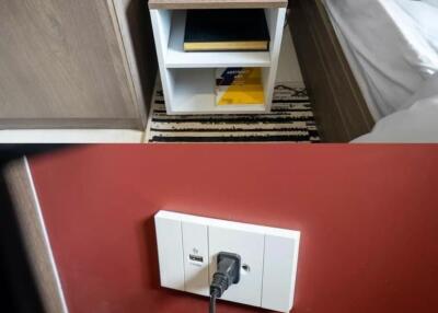 Bedroom nightstand with decorative items and electrical outlet