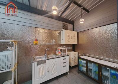 Modern kitchen with metallic backsplash and white cabinets