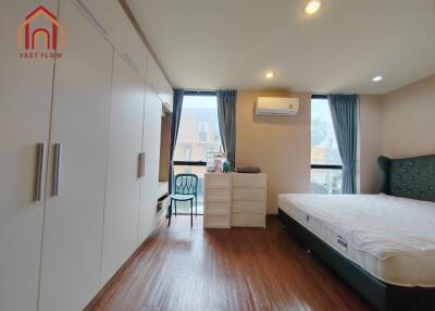 Spacious bedroom with a bed, wardrobe, and air conditioning