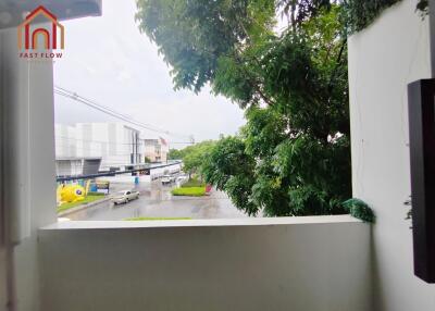 Balcony overlooking street with lush greenery