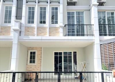 Front view of a townhouse with balcony and fenced yard