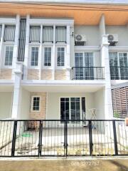 Front view of a townhouse with balcony and fenced yard