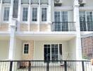 Front view of a townhouse with balcony and fenced yard