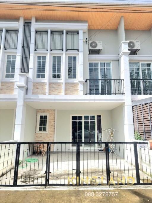 Front view of a townhouse with balcony and fenced yard