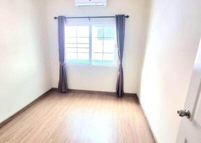 Empty bedroom with window and AC