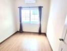 Empty bedroom with window and AC