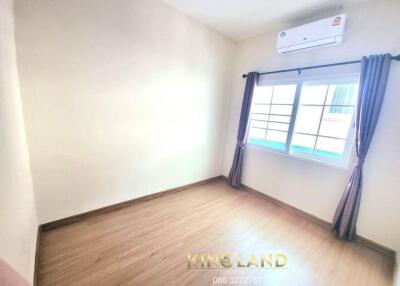 Empty bedroom with wooden floor and window with curtains